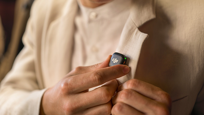 Nadajnik DJI Mic 3 czarny grafika przedstawia mężczyznę przypinającego nadajnik do koszuli